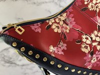 Curved semi-slouchy handbag with matching eyewear/sunglass case, in a floral pattern in cream, pink, and maroon tones, with a rich solid navy